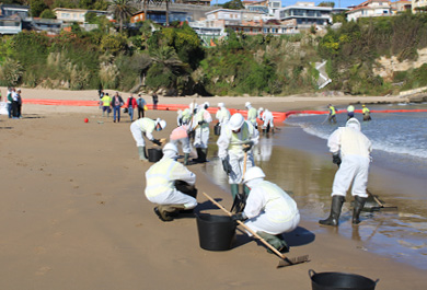 Participantes del simulacro trabajando en la playa de Suances con trajes especiales