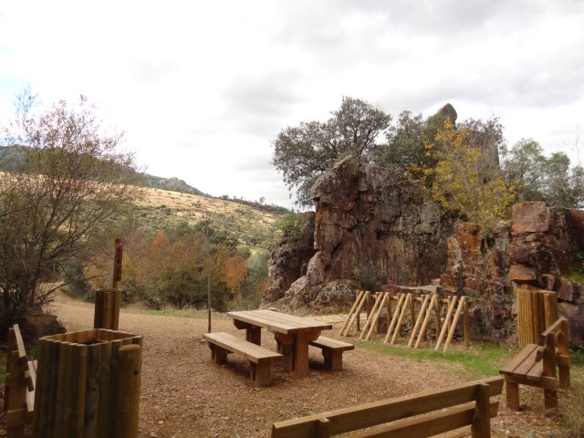 Zona de descanso con bancos y mesa de madera