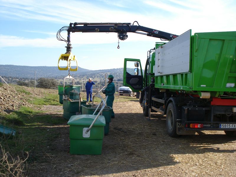 Camión recogiendo contenedores con animales
