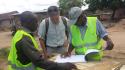 Trabajador de Tragsa viendo planos de obra con técnicos ghaneses