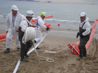 Operarios desplegando barreras selladoras en el simulacro.