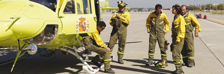 Brigadistas junto a helicóptero 